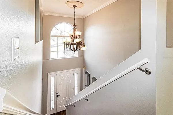 a view of a hallway with windows and chandelier