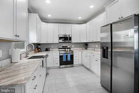 a kitchen with cabinets stainless steel appliances and a counter space