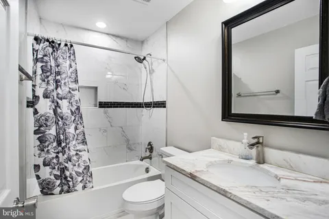 a bathroom with a granite countertop sink toilet and shower