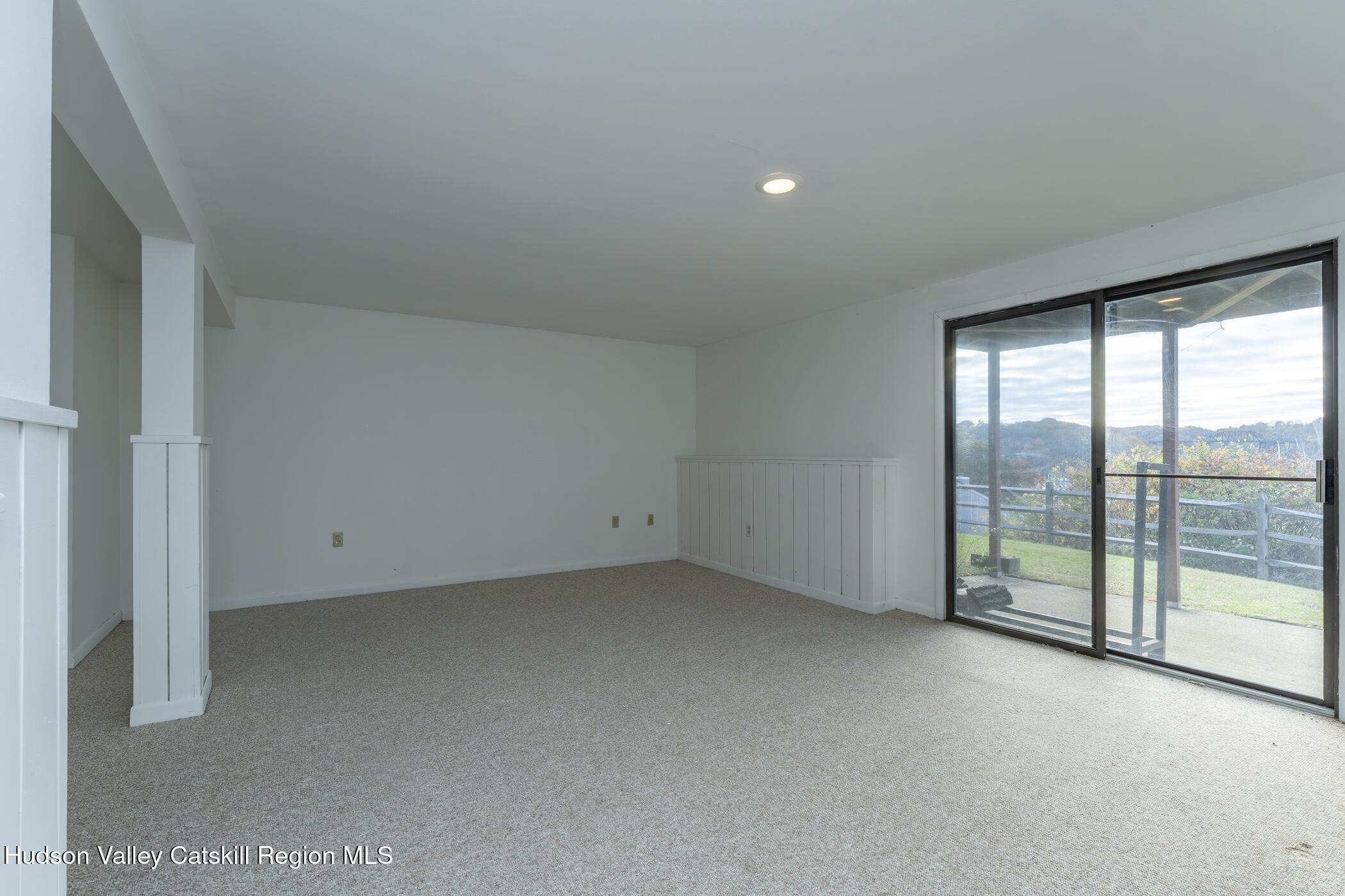 34 Rondout Harbor Port Ewen, NY 12466 - Photo 26 of 42 an empty room with sliding glass door and garden view
