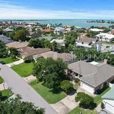 an aerial view of a house with a yard and lake view in back
