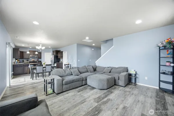 a living room with furniture and view of kitchen