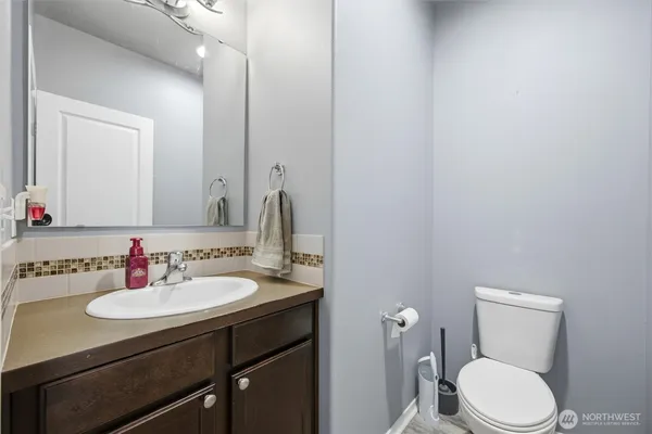 a bathroom with a sink a toilet and mirror