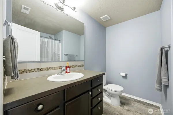 a bathroom with a sink toilet and a mirror