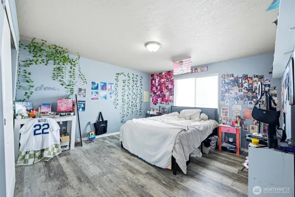 a bedroom with a bed and a wooden floor