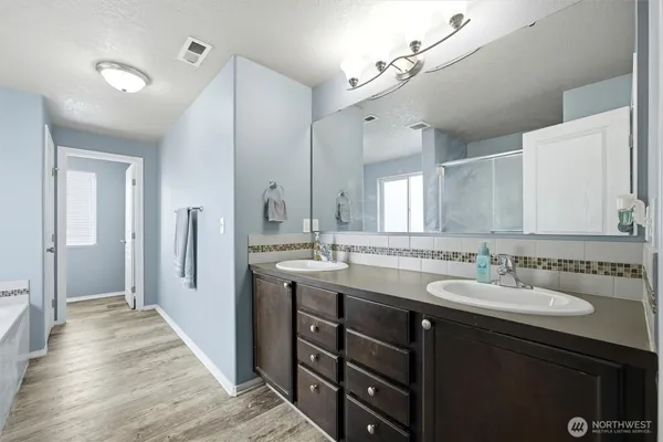 a spacious bathroom with a double vanity sink and a mirror