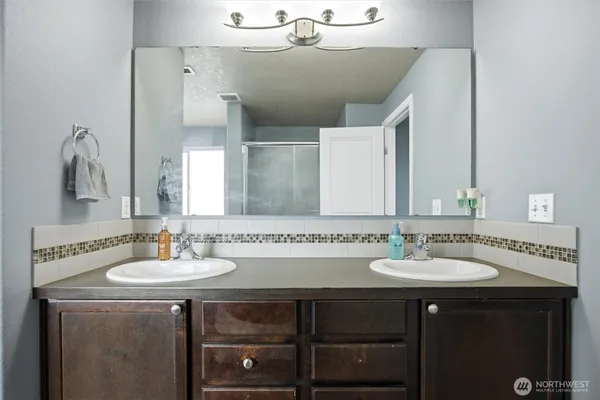 a bathroom with a double vanity sink and a mirror