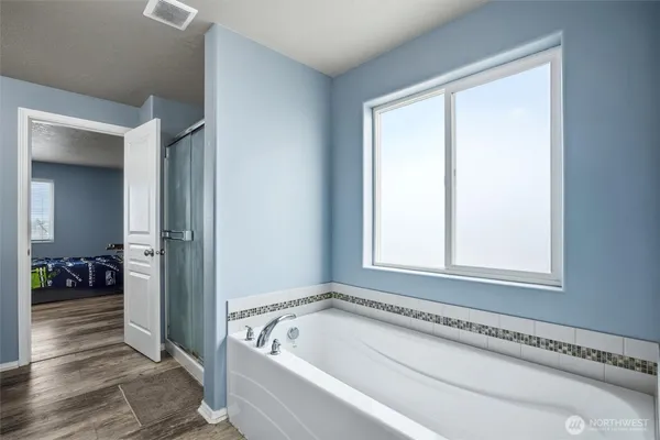 a bathroom with a bathtub and a window