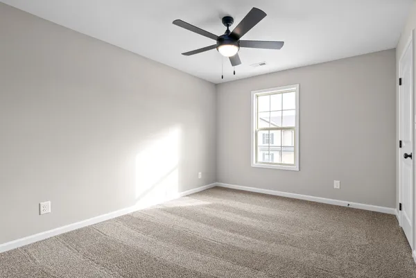 an empty room with a window and a fan