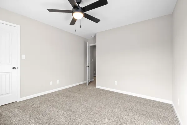 an empty room with chandelier fan
