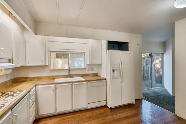 a kitchen with a refrigerator sink and cabinets