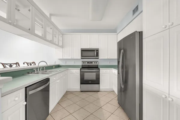 a kitchen with stainless steel appliances granite countertop a refrigerator and a sink