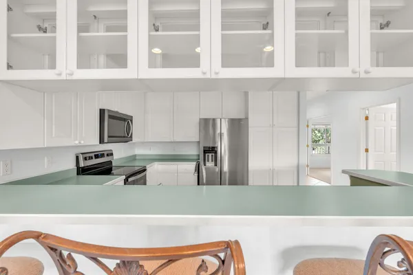 a kitchen with stainless steel appliances kitchen island a refrigerator sink and cabinets