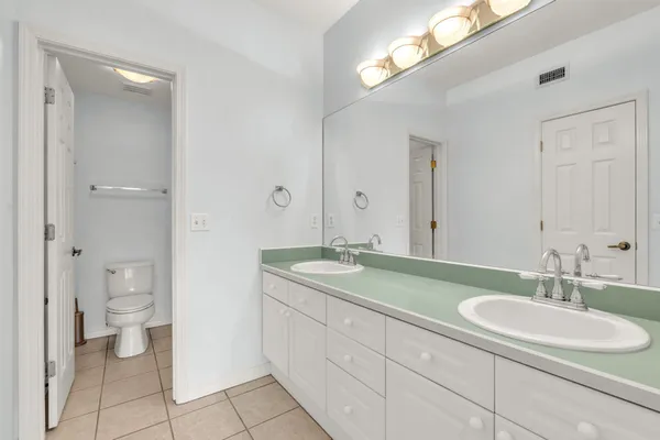 a spacious bathroom with a granite countertop sink toilet and a mirror