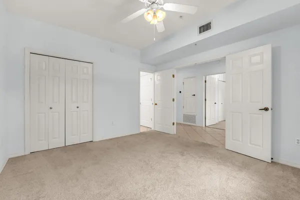 a view of an empty room with a chandelier fan