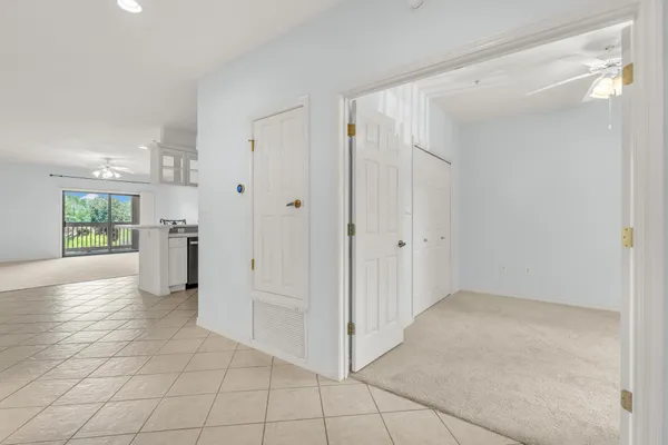 a view of a refrigerator in kitchen and an empty room