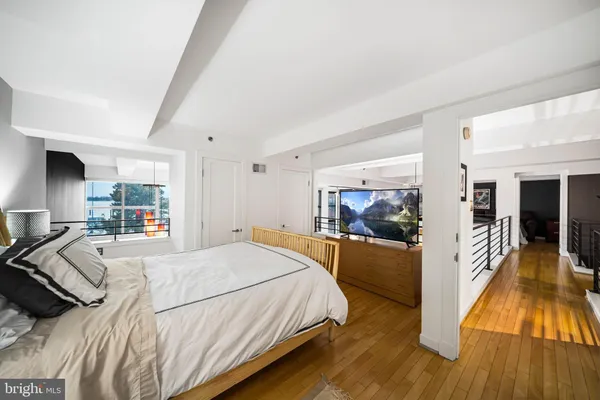 a bedroom with a bed and a view of living room