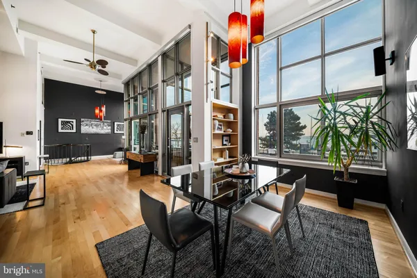 a dining room with furniture and a floor to ceiling window