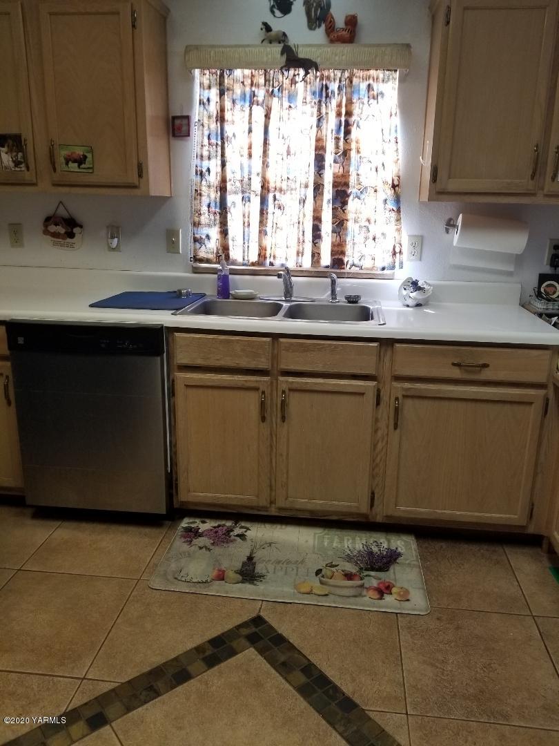 410 West Slavin Road Yakima, WA 98903 - Photo 2 of 19 a kitchen with granite countertop a sink window and cabinets