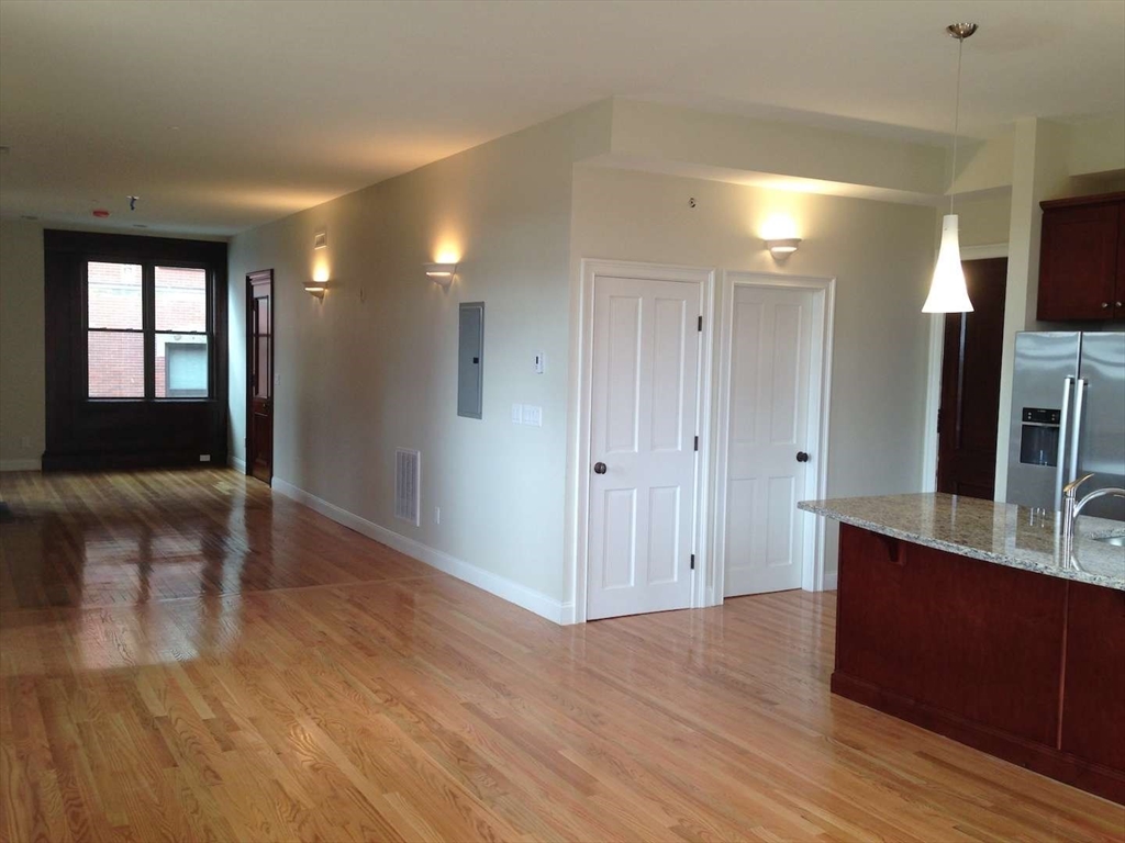191 Main Street, Unit 2B Gloucester, MA 01930 - Photo 10 of 20 a view of a hallway with wooden floor and cabinet
