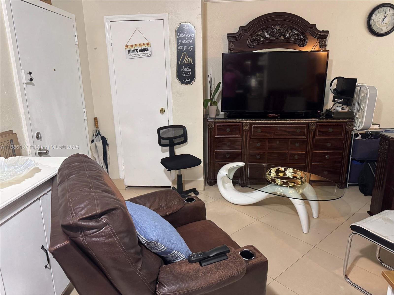 1825 West 56th Street, Unit 107 Hialeah, FL 33012 - Photo 2 of 6 a living room with furniture and a flat screen tv