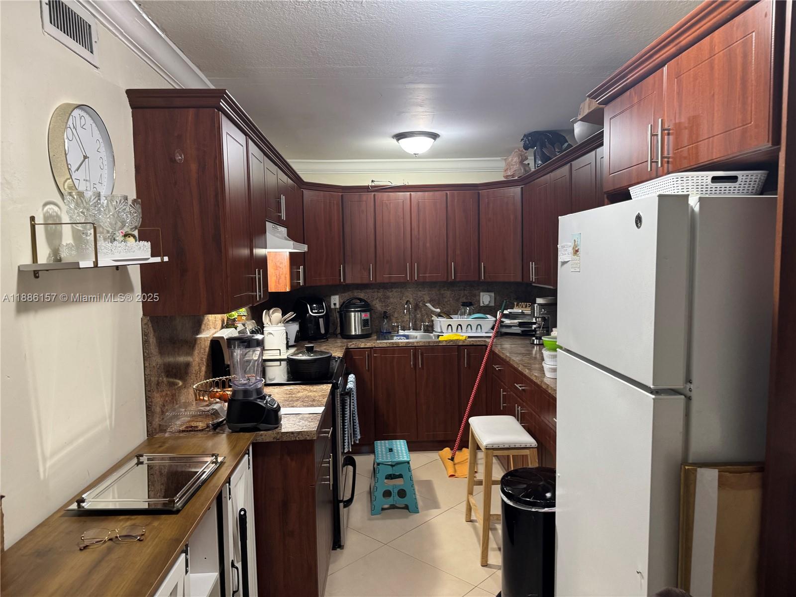 1825 West 56th Street, Unit 107 Hialeah, FL 33012 - Photo 3 of 6 a kitchen with a refrigerator a stove top oven a sink and dishwasher