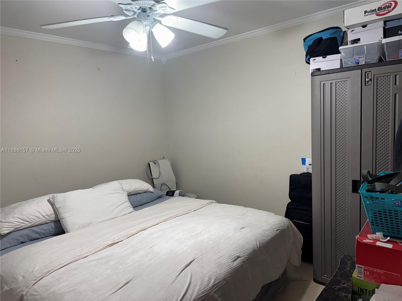 1825 West 56th Street, Unit 107 Hialeah, FL 33012 - Photo 4 of 6 a bedroom with a bed and a chandelier