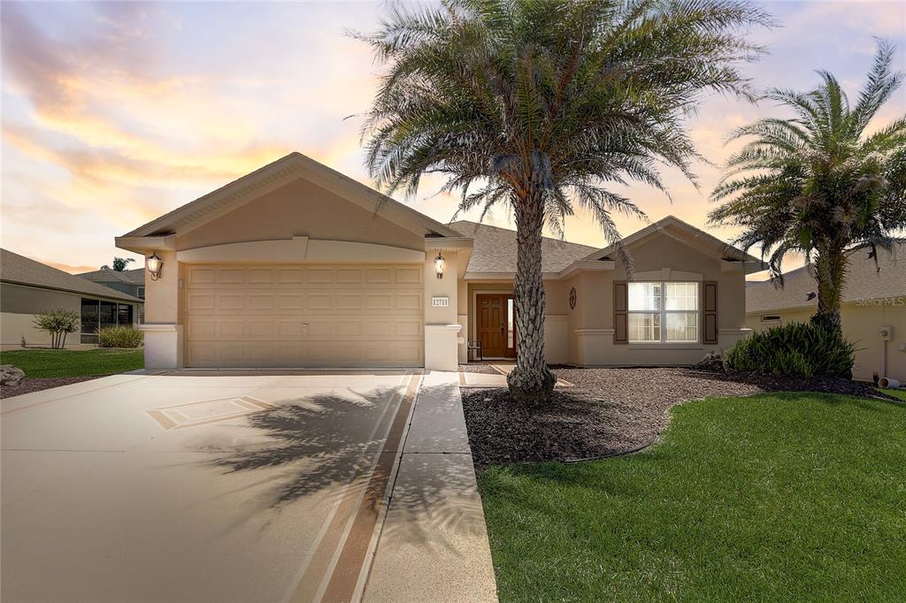 a front view of a house with a garden and trees