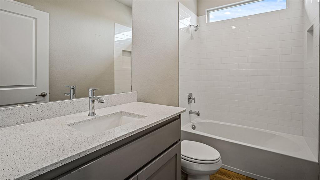 105 Hugo Court Rhome, TX 76078 - Photo 25 of 40 a bathroom with a granite countertop sink a toilet and shower