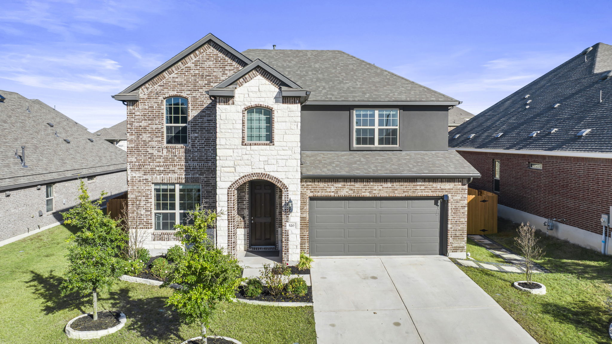 520 Landing Lane Leander, TX 78641 - Photo 1 of 1 Two-story residence featuring a brick and stone exterior, arched entry, and a two-car garage