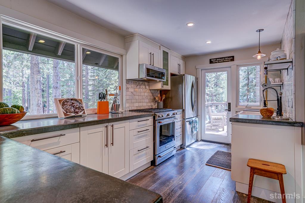 742 Kiowa Drive South Lake Tahoe, CA 96150 - Photo 12 of 26 a kitchen with stainless steel appliances granite countertop a refrigerator a sink dishwasher a stove and white countertops with wooden floor