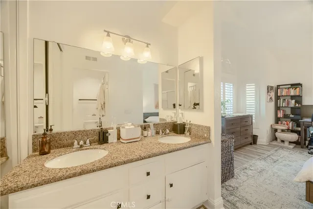 a spacious bedroom with a bed a chandelier and a walk in closet