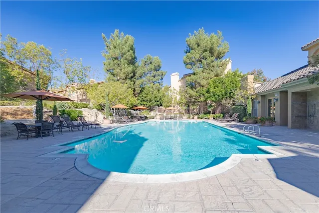 a view of an outdoor dining space with furniture and umbrella