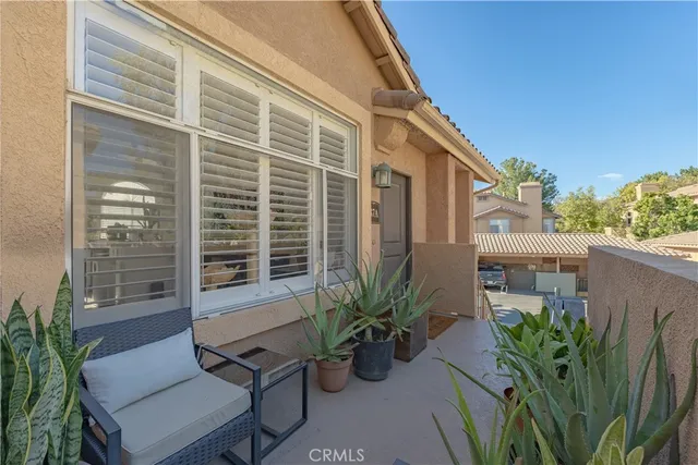 a front view of a house with stairs and a large tree