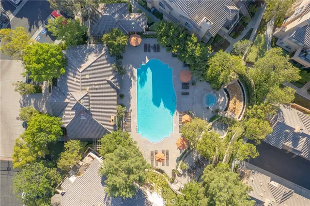 an aerial view of residential houses with outdoor space and trees