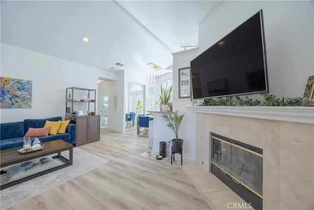 a living room with furniture a flat screen tv and a fireplace