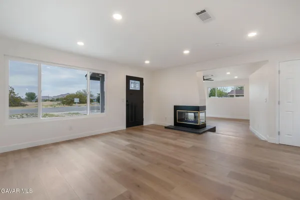 an empty room with wooden floor and a fireplace