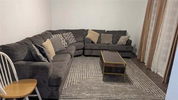 a living room with furniture a lamp and a rug