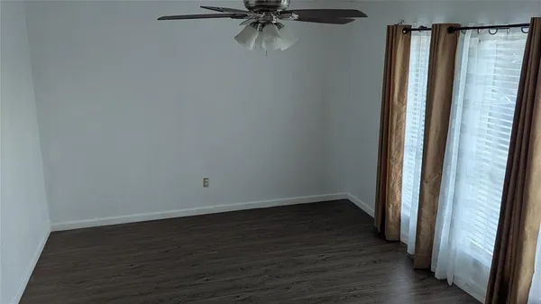 a view of a hallway with wooden floor and a chandelier