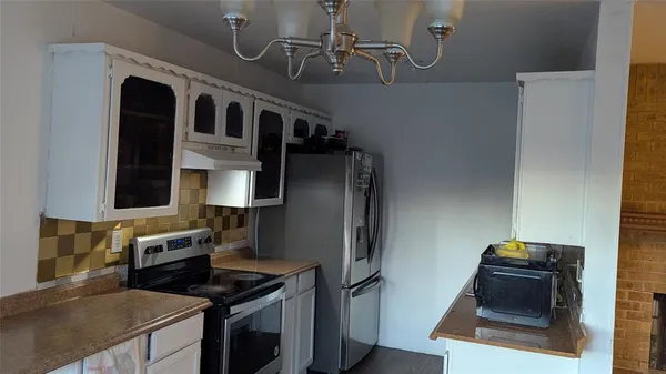 a kitchen with stainless steel appliances granite countertop a refrigerator and a stove