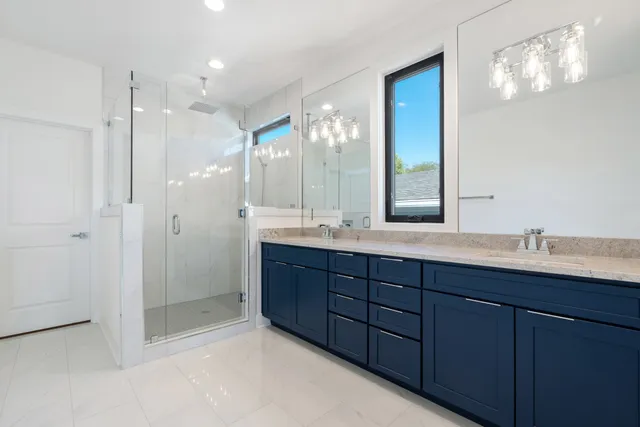 a bathroom with double vanity sinks and a mirror