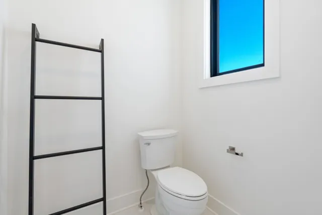 a white toilet sitting next to a shower
