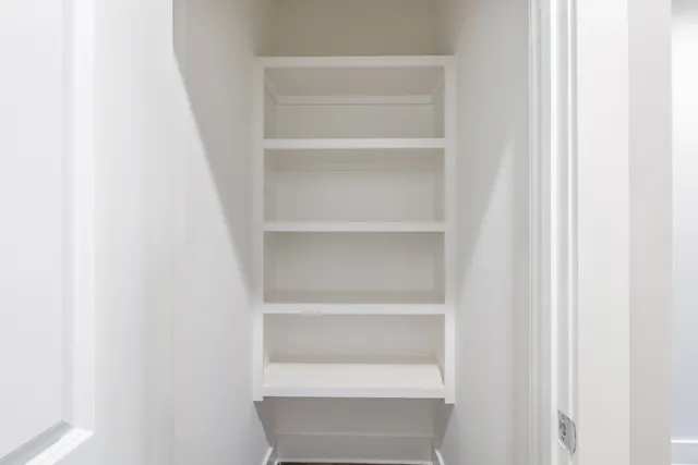 a view of walk in closet with empty racks