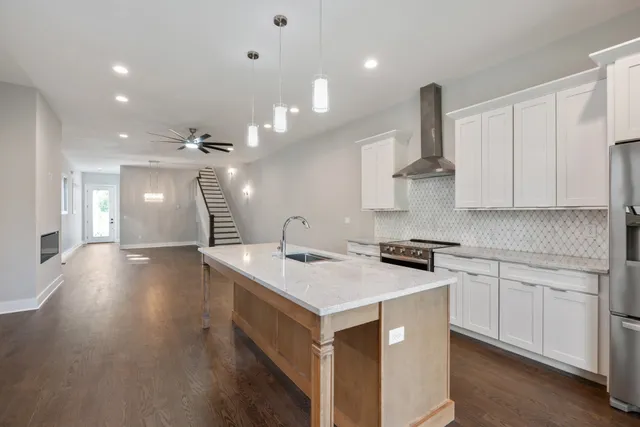 a kitchen with a sink a stove cabinets and wooden floor