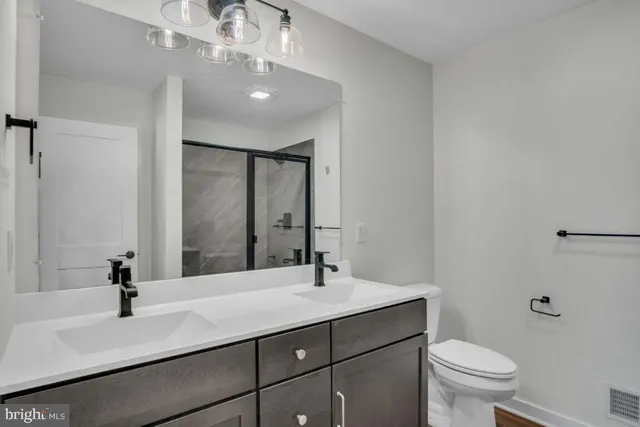 a bathroom with a sink a toilet and a mirror