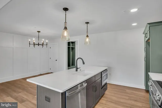 a kitchen with a sink a counter space and wooden floor