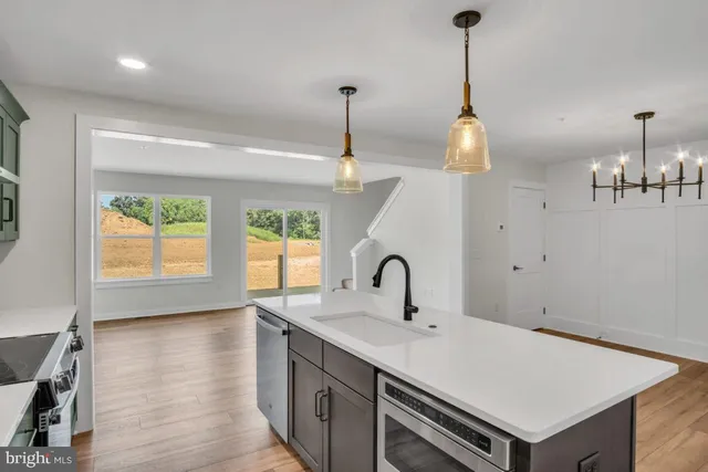 a kitchen with a sink a stove and a wooden floor
