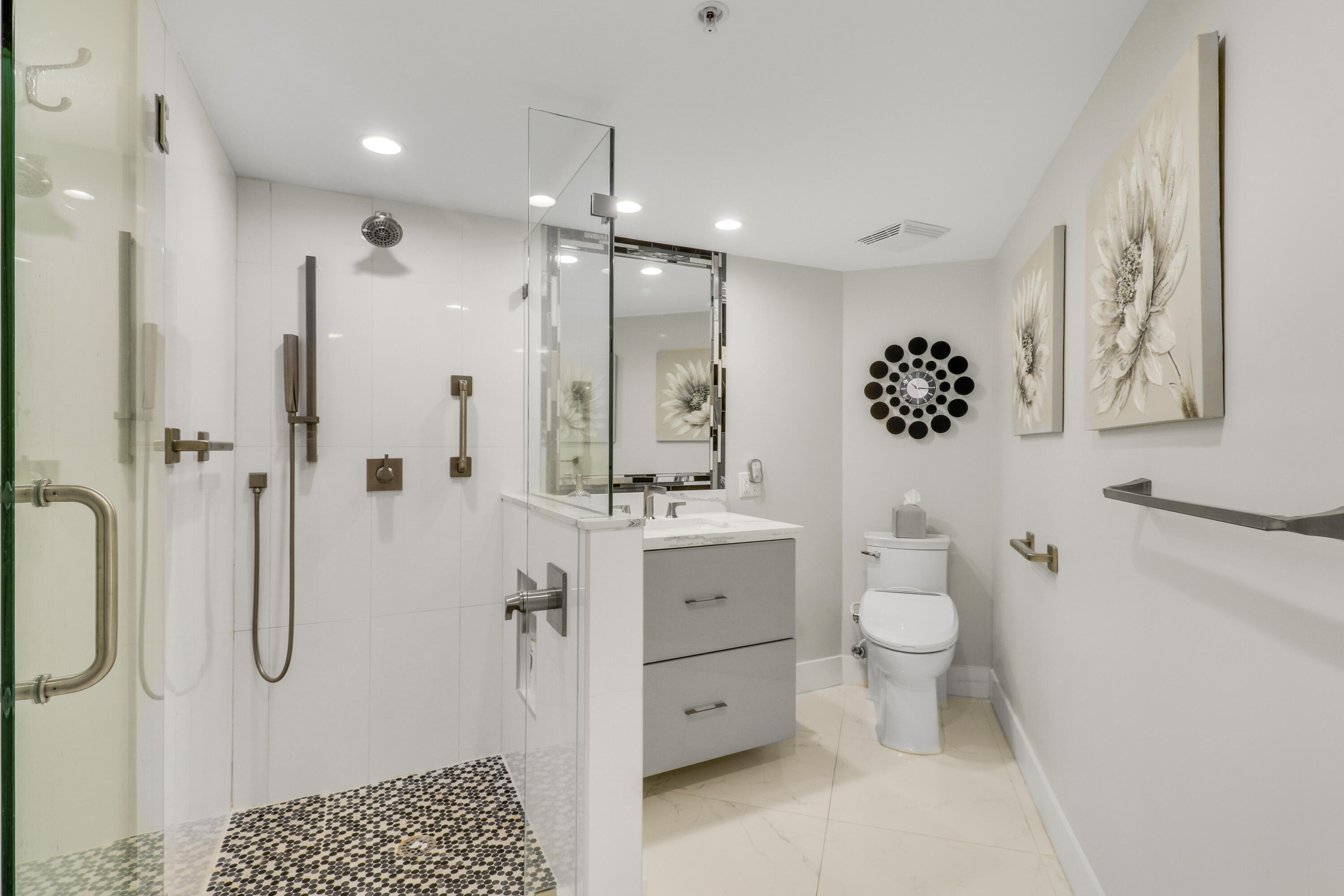 3000 North Ocean Drive, Unit 19H Singer Island, FL 33404 - Photo 30 of 43 a bathroom with a granite countertop sink a toilet a mirror and shower