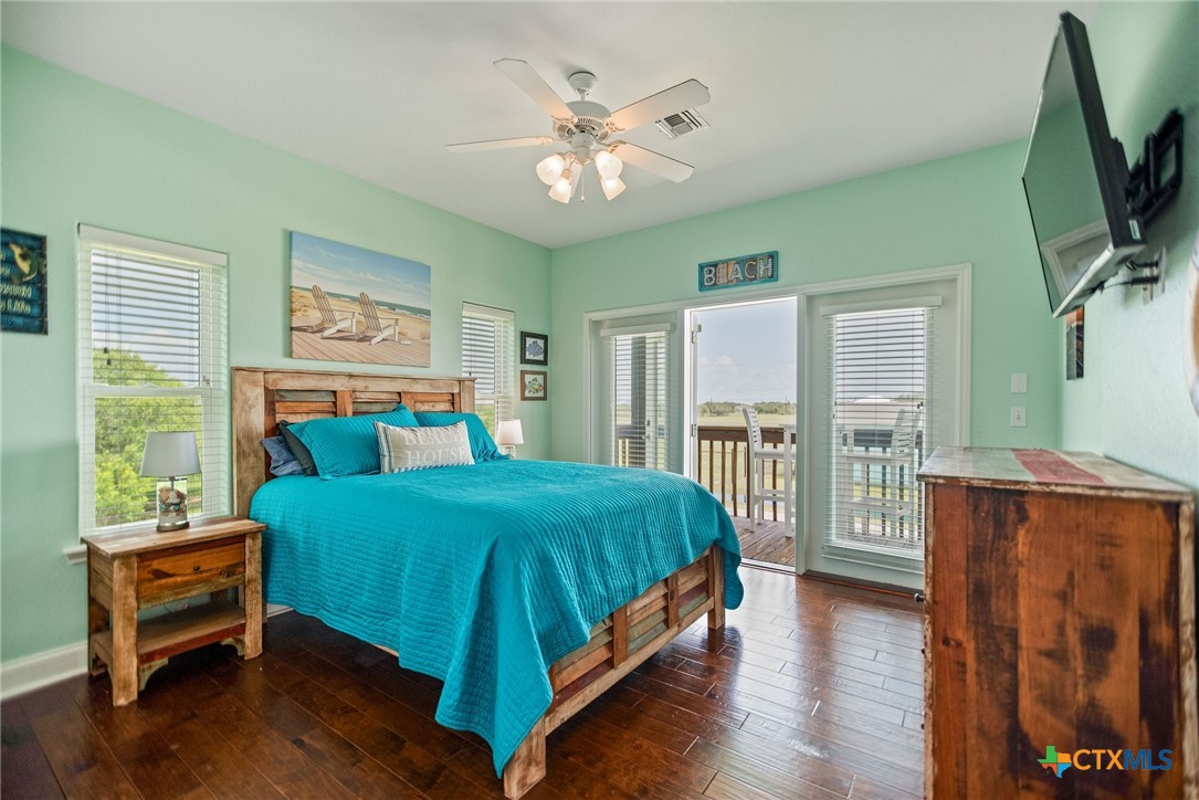 23 Macey Street Port O'Connor, TX 77982 - Photo 29 of 47 a bedroom with a large bed and a chandelier