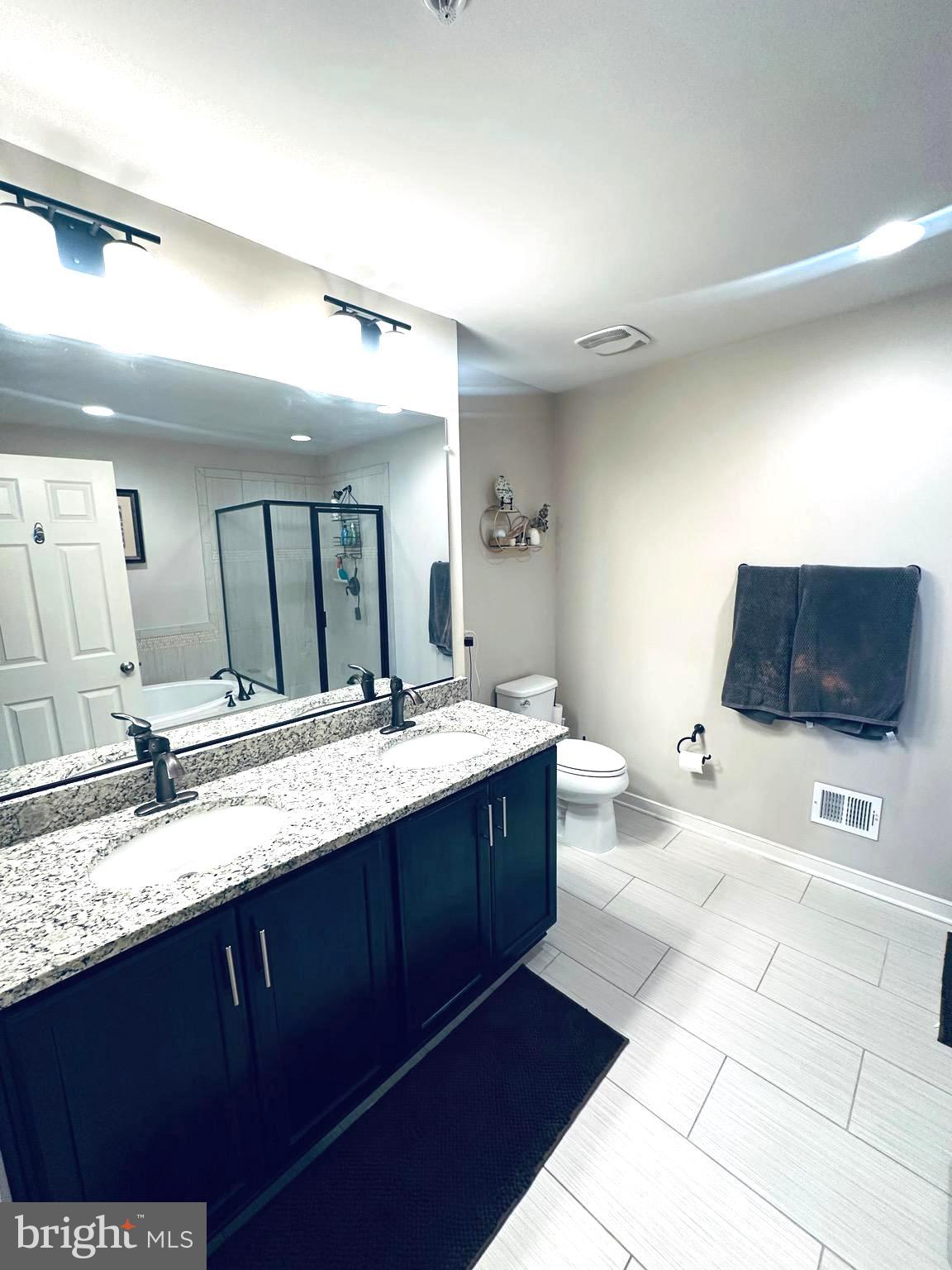 25576 Tolar Square Chantilly, VA 20152 - Photo 16 of 36 a spacious bathroom with a granite countertop sink mirror and a bathtub